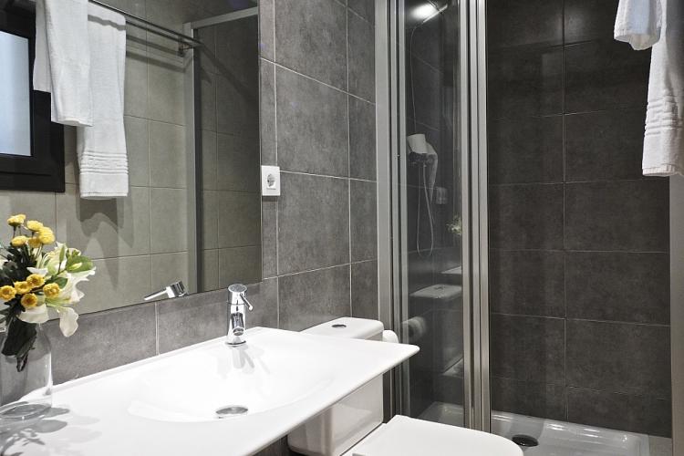 The bathroom is equipped with the shower, modern sink and clean towels
