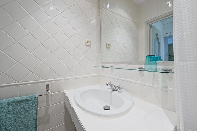 Smooth white tiles provide a sparkling clean feel to the bathroom.