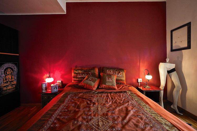 The bed is decorated with colorful sheets for a vibrant look.