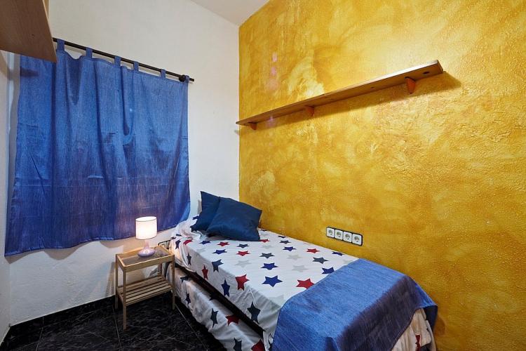 The first room is very colorful, with yellow walls and bright blue curtains.