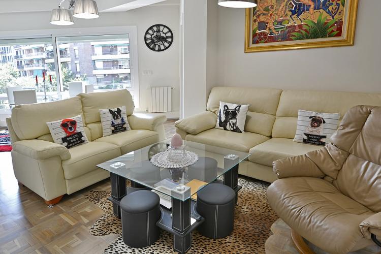 This high-class apartment comes with a cozy living room furnished with soft beige couches.
