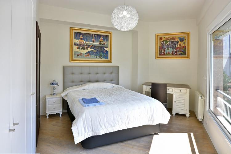 The master bedroom comes with gorgeous paintings on the wall, an antique desk and nightstand and a huge window that allows plenty of light to flood in.