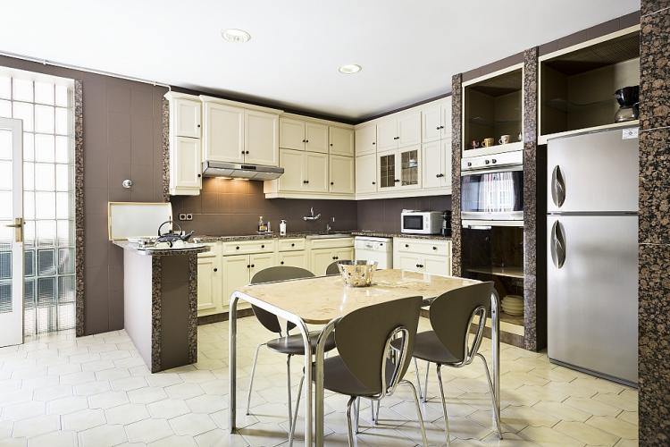 The kitchen comes with an open work area with U-shaped counters facing a dining table for 4.