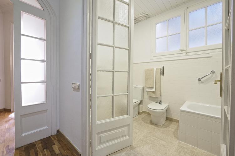 The bathroom features beautiful french doors leading to the hallway
